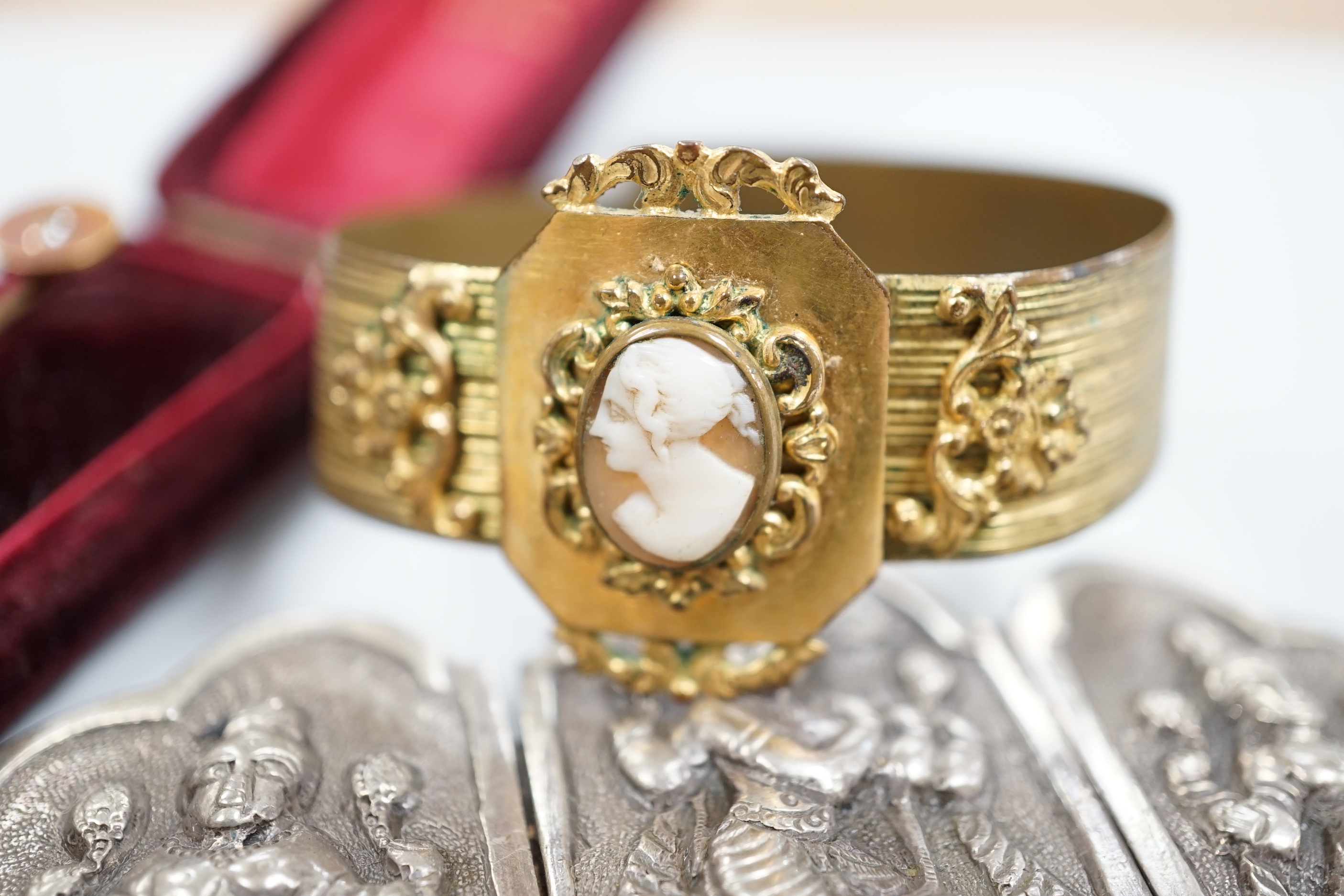 A Victorian yellow metal oval morning locket, with hair beneath a glazed panel verso, overall 56mm and four other items including a pinchbeck bangle.